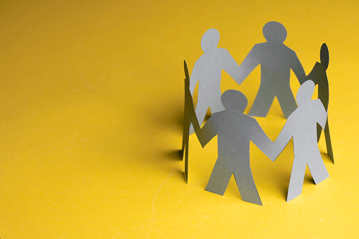Paper cutouts holding hands